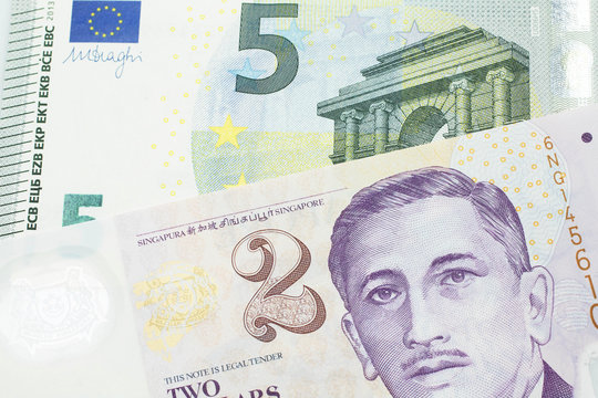 A close up image of a fve euro bank note from the European Central bank and the European Union in macro with a two dollar bill from Singapore