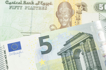 A close up image of a colorful fifty Egyptian piastres note close up in macro with a blue and green, European five euro bank note