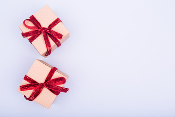 Craft boxes with red ribbon bows. Holiday, Christmas, New Year and Valentine day eco-friendly wrapping concept. Trendy minimalistic flat lay design background. Horizontal