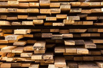Stacked lumber background. Folded wood. Close-up cross section of board. boards stick out from pile of lumber. Lumber for use in construction.