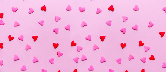 Two tone heart sprinkles on the solid pink background. Romance, love, Valentines and mother's day concept. Flat lay, horizontal wide screen banner format