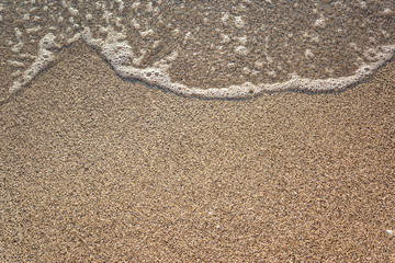 Close-up of sandy beach with soft waves