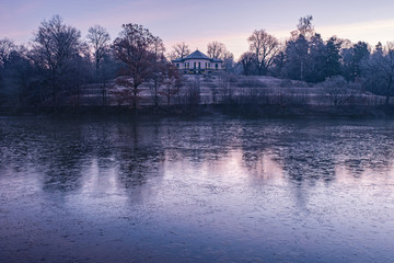 Atmospheric view on the "Bärenschlössle" and the frozen lake "Pfaffensee" at sunrise — Stuttgart, Germany