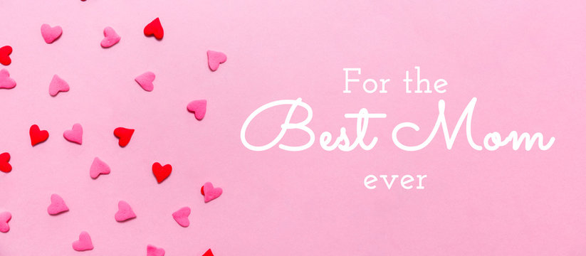 For the Best Mom ever wording and two tone heart sprinkles on the solid pink background. Romance, love, Valentines and mother's day concept. Flat lay, horizontal wide screen banner format