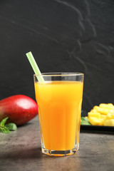 Fototapeta na wymiar Fresh delicious mango drink on grey table
