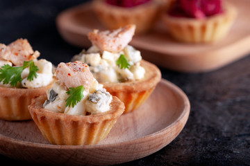 Tartlets with chicken, boiled eggs, cucumbers, spices and herbs.