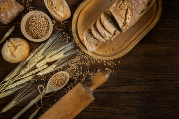 Bread, traditional bread and wheat on wooden backround.