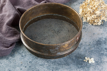 Antique brass  sieve on concrete background.