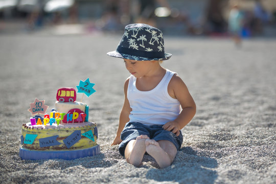 Sweet boys, celebrating on the beach birthday with car theme cake and decoration