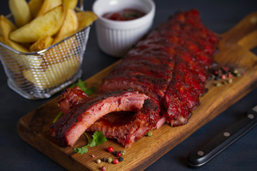 Rack of ribs, barbecue sauce, fries and light beer. Horizontal image