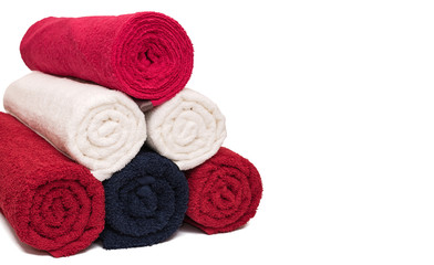 Fototapeta na wymiar Stack of rolled clean soft bath towels on white background. Closeup. Copy space