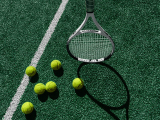 Tennis court Top view Six tennis balls and racket on the green grass background