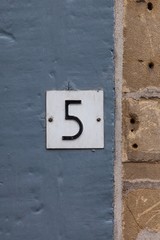 number 5 house number sign on blue wall