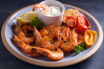 Shrimps with sauce, lemon and vegetables. Seafood