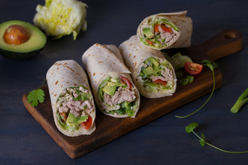 Chicken wraps with avocado, tomatoes and iceberg lettuce. Tortilla, burritos, sandwiches, twisted rolls