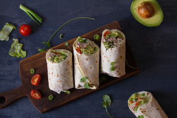 Chicken wraps with avocado, tomatoes and iceberg lettuce. Tortilla, burritos, sandwiches, twisted...