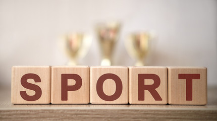 The text of the Sport on wooden cubes, in the background of the cups