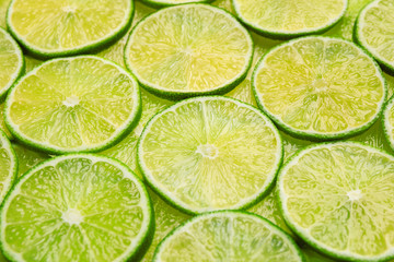 Many fresh juicy lime slices as background, closeup