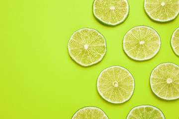 Fresh juicy lime slices on yellow background, flat lay. Space for text
