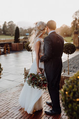 bride and groom kissing in the park in the sunset light