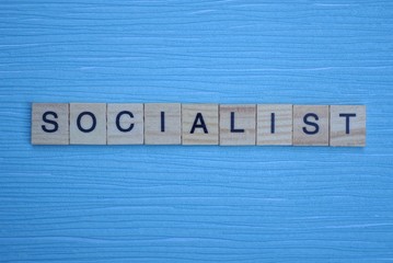  gray word socialist from small wooden letters on a blue table