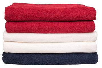 Stack of neatly folded clean soft bath towels after laundry on white background. Closeup