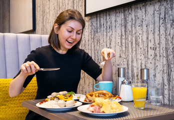 the woman ordered a lot of food in the restaurant and is going to eat all of it. good appetite in the restaurant