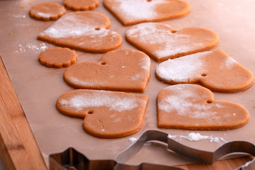 Preparation for the holiday. Preparing for the new year. Gingerbread blanks before baking. Gingerbread cookies with holes for hanging on a Christmas tree. Holiday preparation.