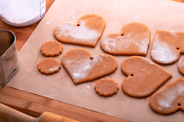 Preparation for the holiday. Preparing for the new year. Gingerbread blanks before baking. Gingerbread cookies with holes for hanging on a Christmas tree. Holiday preparation.