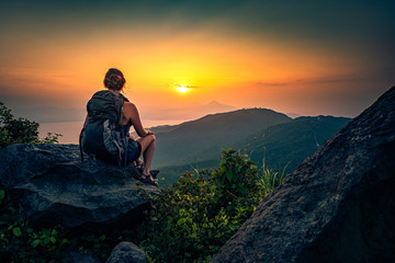 Young woman admire beautiful sunset over The Da Nang Bay and Ba Na mountains from the viewpoint,...
