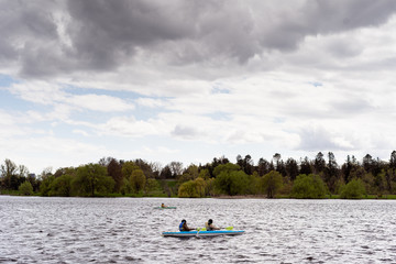 Fototapeta na wymiar couple in kayak during cloudy day in Dow's Lake during early spring. Ottawa, Ontario, Canada