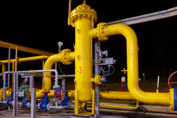 Pipeline system at a gas production and processing plant. Pipes, valves, manometers. Night shooting