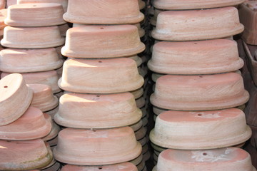 open air workshop of ceramics, earthenware, orange and brown terracotta flower pots