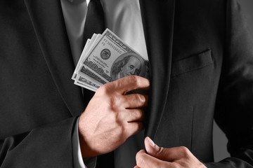 Man with bribe money on dark background, closeup