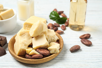 Composition with organic cocoa butter on white wooden table, closeup
