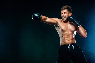 Fitness and boxing concept. Boxer, man fighting or posing in gloves on dark background. Individual sports recreation.