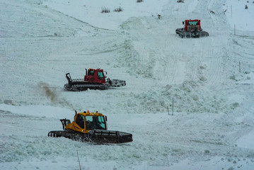 Snowcats on mountainside at ski resort after a winter storm