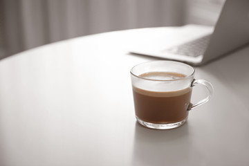 Cup of hot coffee on white table indoors in morning. Space for text