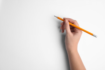 Woman holding pencil on white background, top view