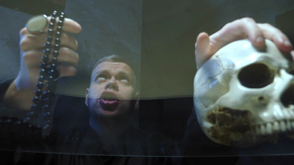 view through a glass countertop. the magician casts a spell . hand on its skull