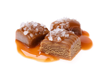 Delicious salted caramel with sauce on white background