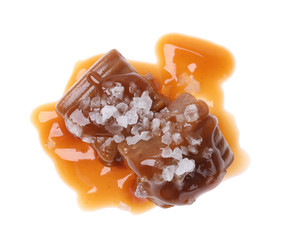 Delicious salted caramel with sauce on white background, top view