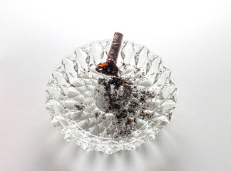 An extinguished cigar in an ashtray isolated on a white background.