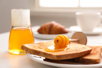 Honey and toasts on white table, closeup