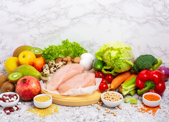 Healthy balanced food background. Organic meat, vegetables, fruits, cereals, legumes, eggs on the gray background, top view, copy space