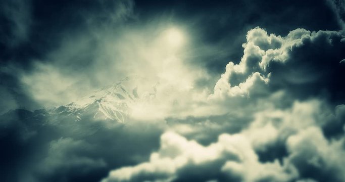 Cinematic Heavy Clouds and Mountains. Foggy Winter Scene and Snowy Sky. View from Above. Filtered Big White Cloud Moving fast across Blue Sky Against a Background of the Sun. Darkly Surreal Atmosphere