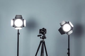 Professional video camera and lighting equipment on grey background