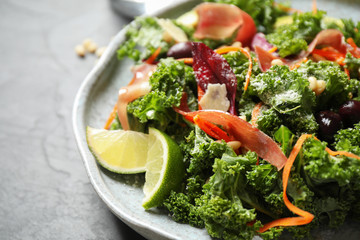 Tasty fresh kale salad on grey table, closeup