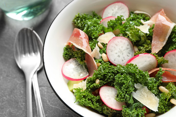 Tasty fresh kale salad on grey table, closeup