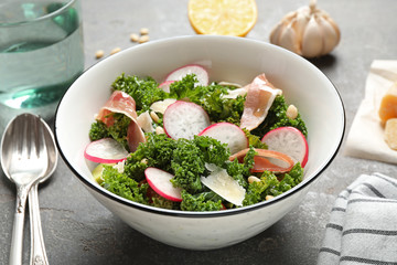 Tasty fresh kale salad on grey table, closeup
